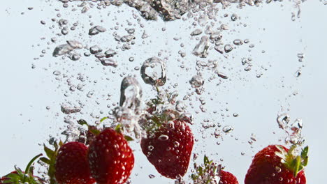 Rote-Erdbeeren-Fallen-Ins-Wasser-In-Superzeitlupe,-Nahaufnahme.-Frische-Beeren-Sinken.