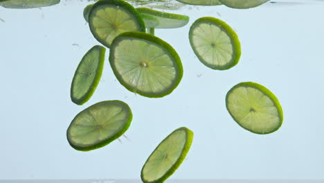 Fresh-lime-submerged-water-on-white-background-close-up.-Citrus-deep-underwater.