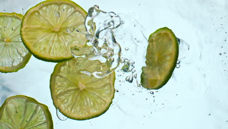 Fresh-lime-slices-falling-water-close-up.-Juicy-pieces-acidic-citrus-floating.