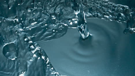 Cold-water-pouring-glass-top-view-closeup.-Transparent-drink-filling-glassware