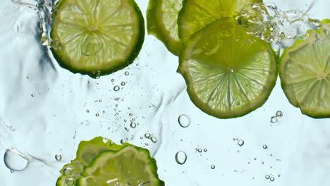 Citrus-pieces-floating-water-in-super-slow-motion-close-up.-Lime-dropped-liquid.