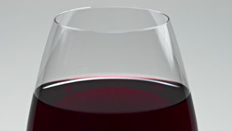 Blob-splashing-inside-wine-glass-closeup.-Drop-falling-inebriant-beverage