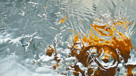 Closeup-oranges-splashing-liquid-top-view.-Sweet-tropical-fruits-falling-drop