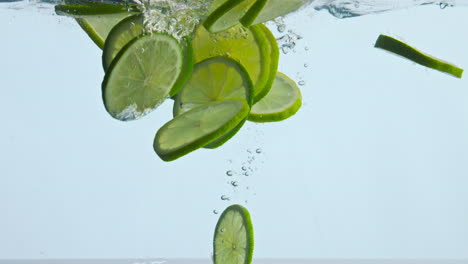 Sliced-sour-lime-water-floating-on-white-background-close-up.-Citrus-underwater.