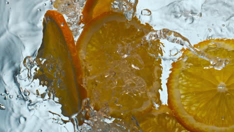 Orangenstücke-Ließen-Wasser-In-Superzeitlupe-Fallen,-Nahaufnahme.-Spritzende-Zitrusfrüchte