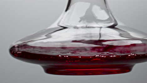 Closeup-decanter-shaking-red-wine-in-slow-motion.-Rose-drink-moving-inside-bowl