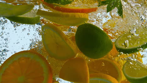 Scheiben-Frischer-Zitrusfrüchte,-Die-Aus-Nächster-Nähe-Ins-Wasser-Fallen.-Orange/Limette-In-Flüssigkeit.
