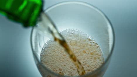 Alkoholischer-Flüssigkeitsstrahl-Sprudelt-In-Transparentes-Glas,-Draufsicht.-Flasche-Gießt-Bier