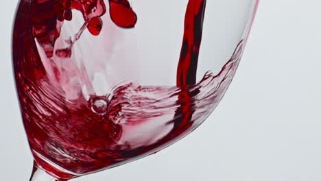 Bubbled-red-wine-beverage-closeup.-Fresh-alcoholic-liquid-swashing-wineglass