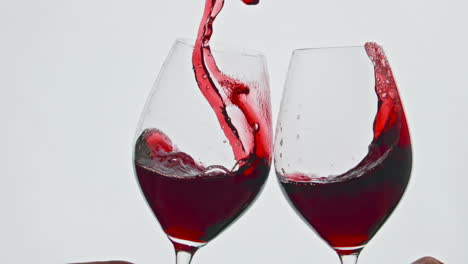 Clinking-raising-red-beverage-vessels-closeup.-Rose-wine-splashing-over-the-edge