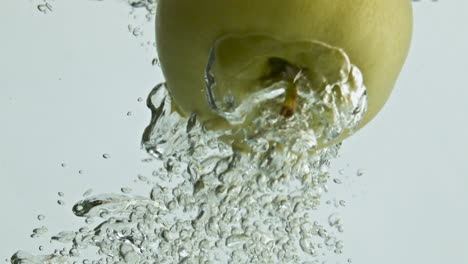 Green-apple-falling-water-closeup.-Tasty-season-fruit-flowing-transparent-liquid