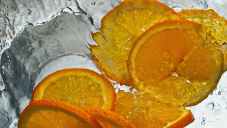 Nahaufnahme-Von-Orangenstücken,-Die-Mit-Glatter-Flüssigkeit-Spritzen.-Zubereitung-Eines-Sommerlichen-Zitruscocktails-In
