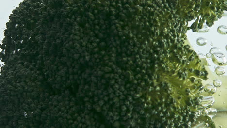 Fresh-broccoli-dropping-water-closeup.-Green-florets-floating-bubbling-liquid-in