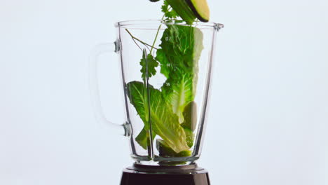 Closeup-blender-green-vegetable-falling-in-bowl-super-slow-motion.-Organic-food