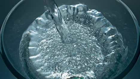 Sparkling-aqua-pouring-glass-top-view-closeup.-Mineral-drink-filling-glassware