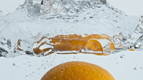 Orangenfrucht,-Die-Im-Wasser-Vor-Hellem-Hintergrund-Spritzt,-Nahaufnahme.-Frische-Tropische-Zitrusfrüchte