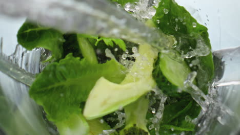 Closeup-water-pouring-blender-with-vegetables-fruits-herbs-in-super-slow-motion.
