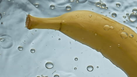 Nahaufnahme-Von-Frischem-Bananenwasser,-Das-Auf-Hellem-Hintergrund-Schwimmt.-Gelbe-Tropische-Früchte