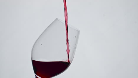 Nahaufnahme-Einer-Roten-Flüssigkeit,-Die-Ein-Weinglas-In-Zeitlupe-Füllt.-Wein-Spritzt-Im-Kelch