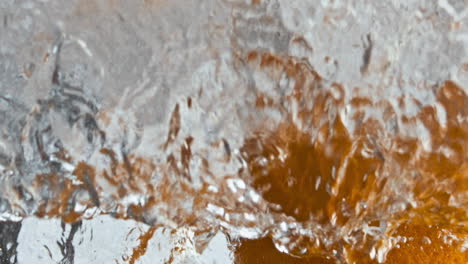 Fresh-oranges-falling-water-making-air-bubbles-closeup.-Organic-tropical-juice.
