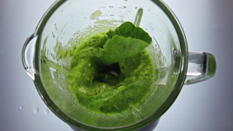 Preparing-green-vegetables-smoothie-in-blender-close-up.-Vitamin-healthy-food.