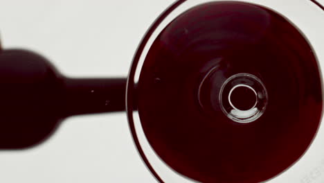 Bottom-view-red-wine-filling-tumbler.-Bordeaux-alcoholic-liquid-inside-wineglass