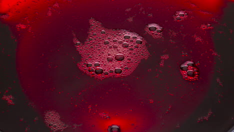 Red-wine-foamy-texture-closeup.-Bubbled-liquid-surface-frothing-moving-top-view