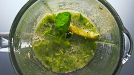 Blender-filled-vegetables-preparing-vitamin-smoothie-super-slow-motion-close-up.