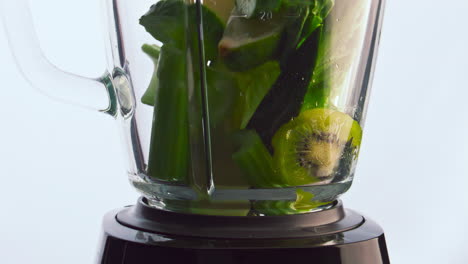 Green-fruits-vegetables-falling-blender-cup-in-super-slow-motion-close-up.
