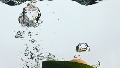 Half-avocado-fall-water-in-super-slow-motion-close-up.-Veggie-dropped-underwater