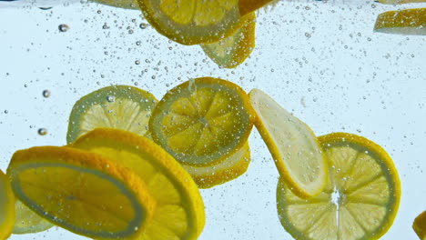 Aufgeschnittene-Zitrone,-Schwimmt-Im-Wasser,-Nahaufnahme.-Leckere-Vitamin-Zitrusfrüchte-In-Die-Flüssigkeit-Getropft.