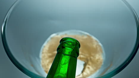 Bottled-lager-beer-pouring-vessel-closeup.-Sparkling-cold-beverage-filling-glass
