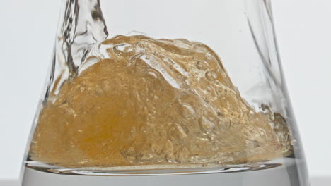 Closeup-hoppy-beer-filling-glass-slow-motion.-Liquid-bubbling-inside-goblet