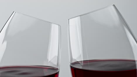 Alcohol-red-drink-clinking-wineglasses-closeup.-Cheering-rose-wine-clear-glasses