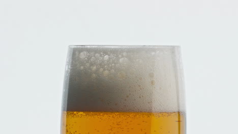 Fondo-Blanco-De-Copa-De-Cerveza-Espumosa-Estática.-Primer-Plano-De-Textura-De-Bebida-Alcohólica-Burbujeada