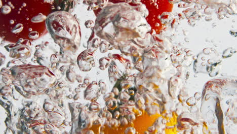 Kirschgemüse-Fällt-Wasser-In-Hellem-Hintergrund,-Nahaufnahme.-Bunte-Tomaten-Fallen