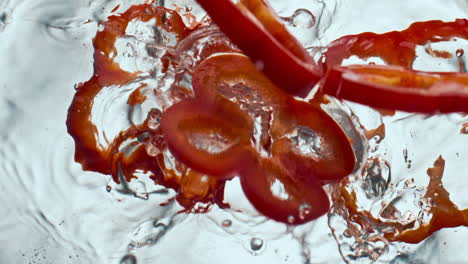 Aufgeschnittener-Roter-Pfeffer,-Fallendes-Wasser-In-Superzeitlupe.-Nahaufnahme-Von-Vitamingemüse