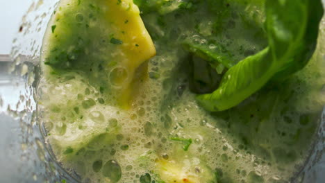 Closeup-preparing-vegetable-smoothie-in-blender-bowl-super-slow-motion-top-view.