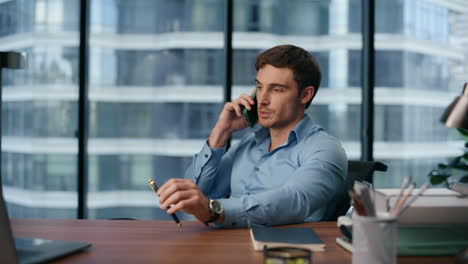 Serious-ceo-answering-phone-call-at-office-closeup.-Man-talking-smartphone