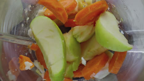 Blender-full-fruits-vegetables-blending-in-super-slow-motion-close-up-top-view.
