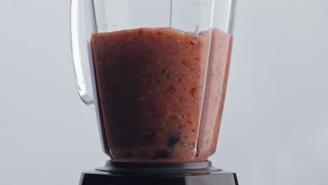 Fruit-berry-cocktail-mixing-in-blender-close-up.-Organic-blend-swirling-in-mixer