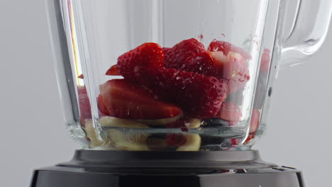 Milk-pouring-blender-fruits-berries-in-super-slow-motion-closeup.-Cook-milkshake