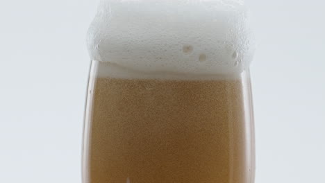 White-beer-foam-bubbling-in-goblet-super-slow-motion.-Drink-pouring-into-glass.