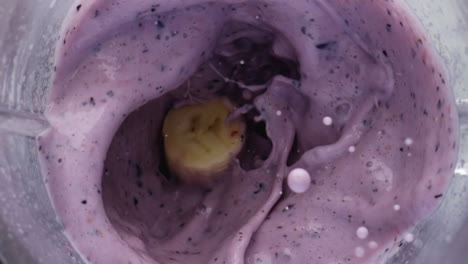 Closeup-berries-falling-smoothie-blending-in-mixer.-Vitamin-yogurt-ingredients.