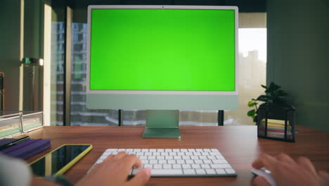 Unknown-woman-typing-mockup-computer-closeup.-Director-arms-working-green-screen