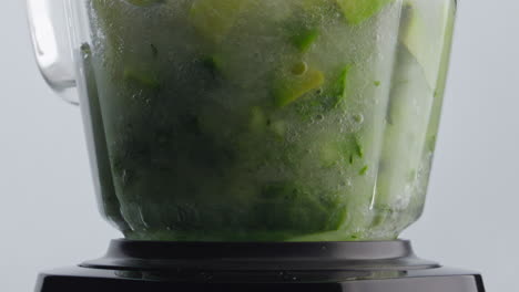 Closeup-vegetables-blending-water-inside-blender-bowl-in-super-slow-motion.