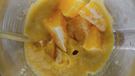Saftige-Orangenstücke-Im-Mixer-Mixen,-Nahaufnahme,-Draufsicht.-Leckeres-Dessert-Kochen.