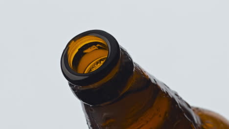Primer-Plano-De-Botella-De-Cerveza-De-Vidrio-Descorchando.-Sidra-Carbonatada-Espumosa-Saliendo-Del-Matraz