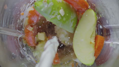 Mixing-milk-fruits-vegetables-in-blender-bowl-close-up.-Preparing-detox-cocktail
