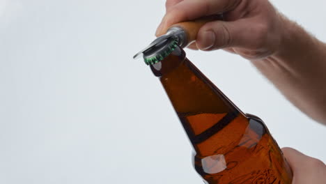 Man-hand-opening-beer-bottle-with-opener-in-super-slow-motion-close-up.